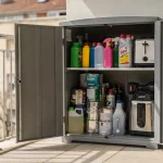 Armadio da esterno aperto su un balcone con detergenti, spray, vernici e batterie riposti in modo rischioso
